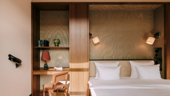 bed in guestroom at Chateau Royal berlin set in wooden back wall with shelf and light detail