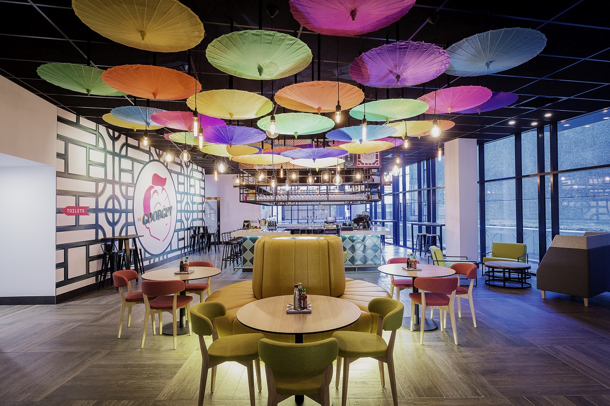 A fun dining space features colourful upside-down paper parasols hung from the ceiling. 