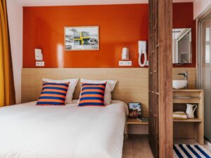 inside cabin with orange wall and striped cushion at camping liberte