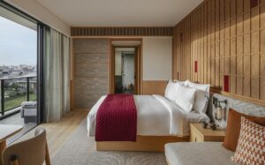 panelled wall behind the bed and views of Kyoto in front at Six Senses hotel guestroom