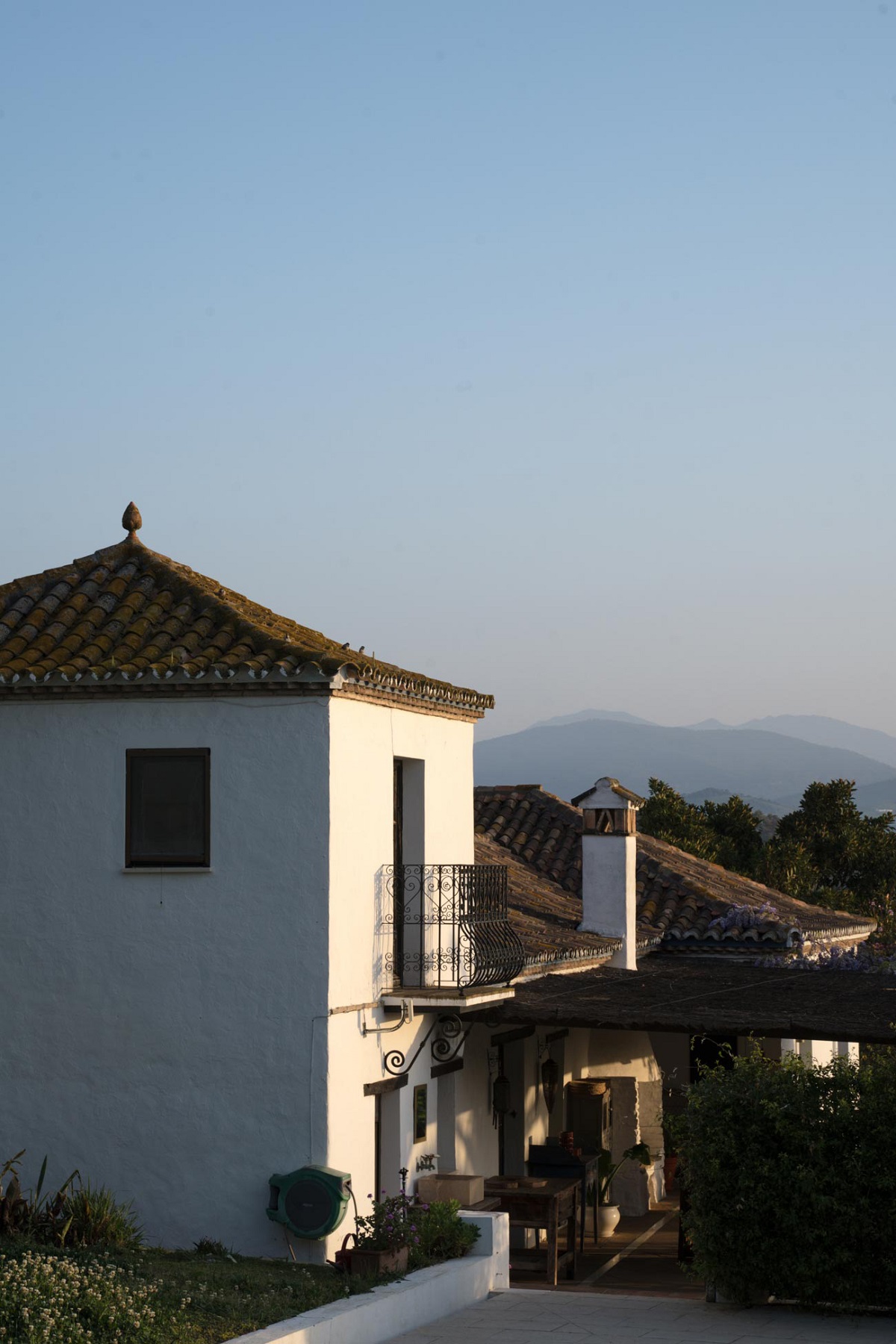 white exterior of finca la gloria farmhouse with balcony in spanish countryside