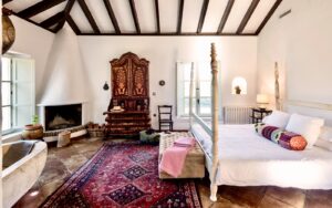 andalucian style interior guestroom with four poster bed and freestanding bath in finca la gloria