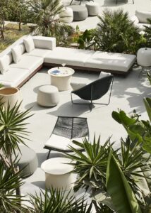 hotel outdoor seating in white framed by green plants and palms in Bodrum