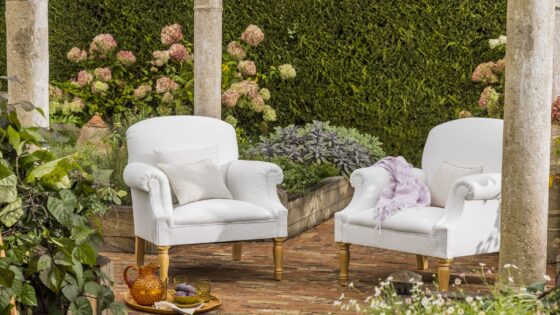 upholstered George Smith chairs in the garden with tea tray