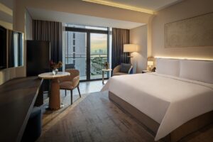 guestroom with double bed and view over dubai