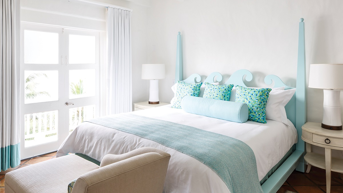 white and turquoise hotel bedroom with seaview