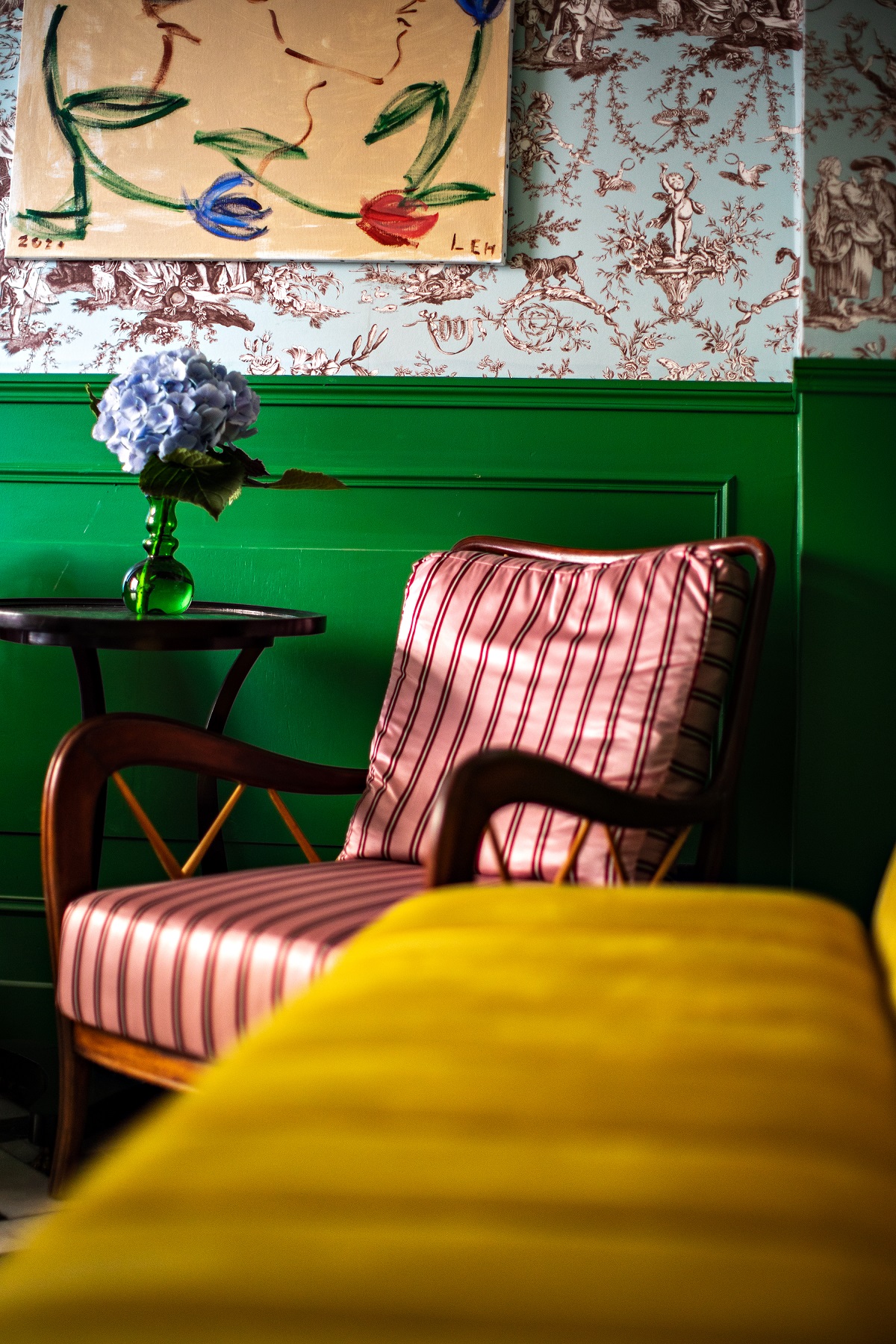 green wall, red stripe chair and yellow velvet in eclectic Paris hotel