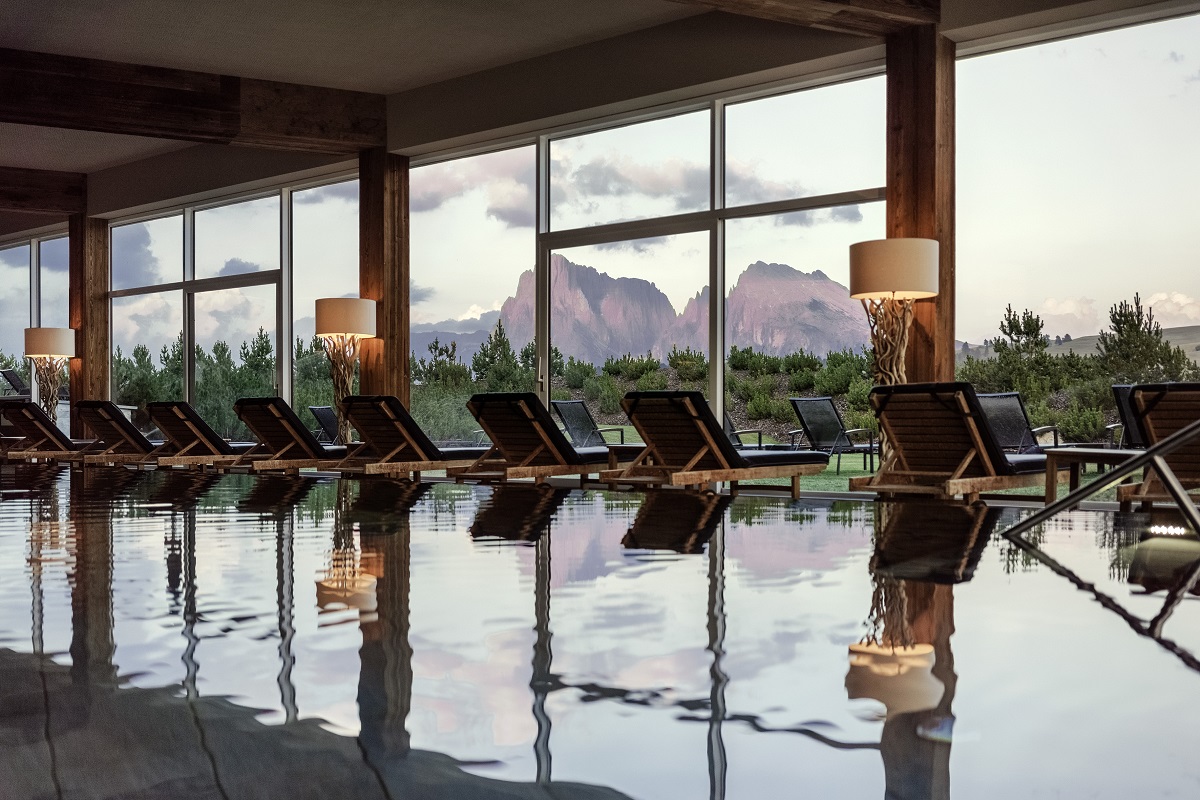 interior pool at COMO hotel with loungers facing a dolomite mountain view