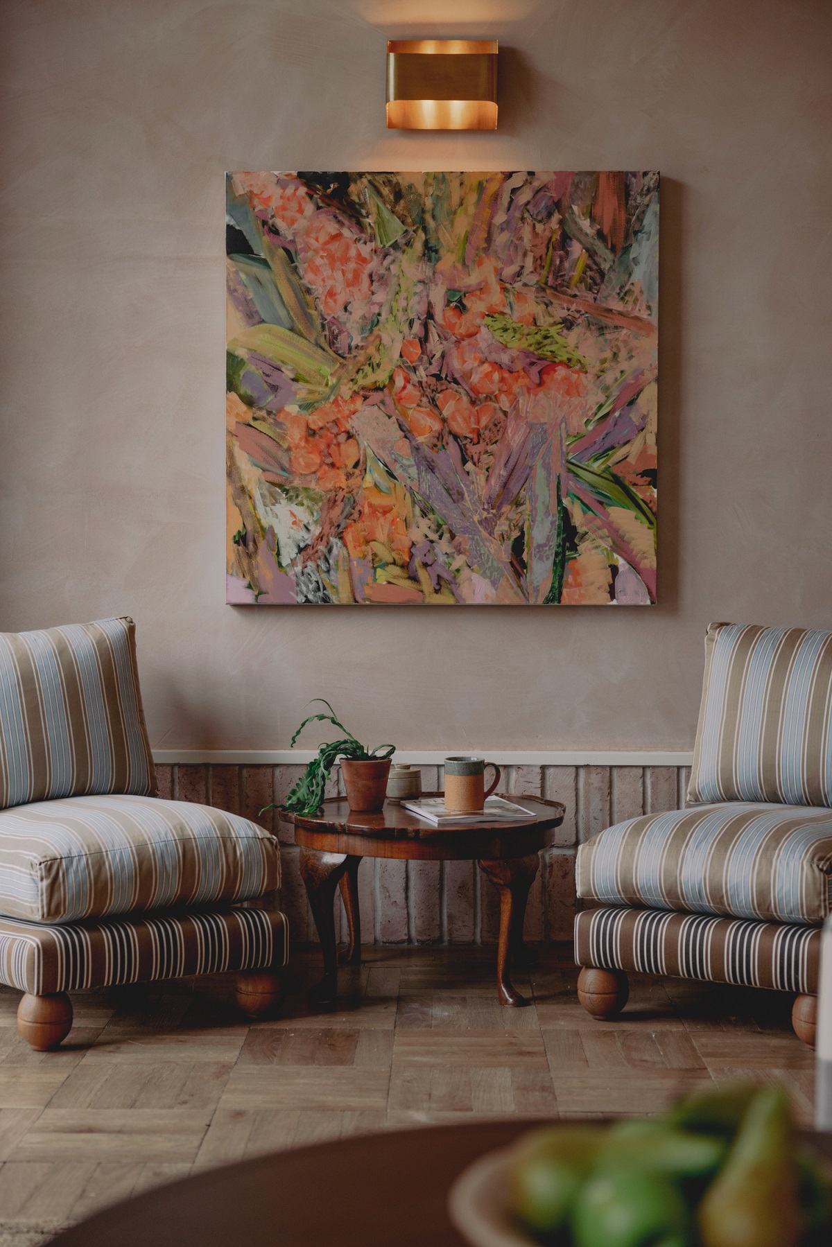 2 striped chairs below colourful contemporary painting