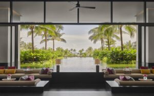 lounge in Regent Phu quoc with windows framing a view of palm trees and pool