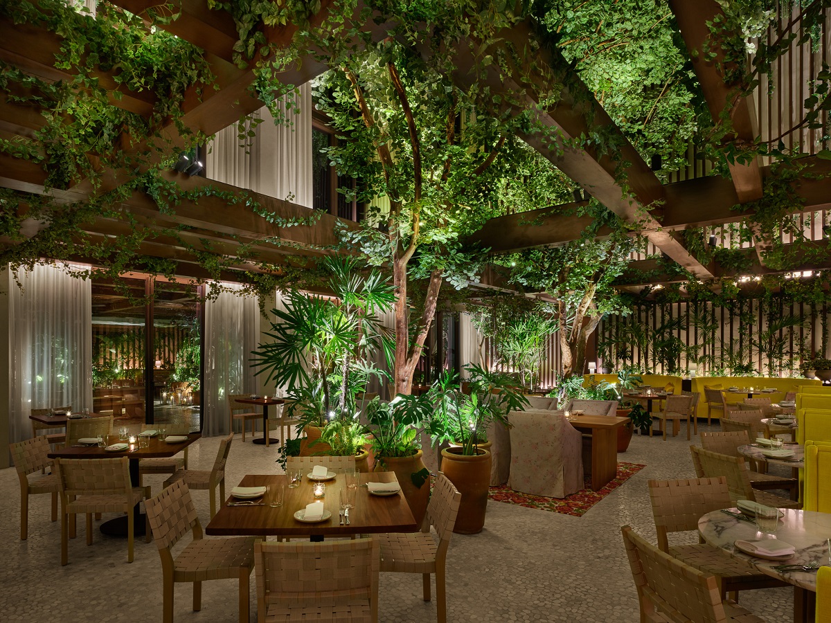 open air restaurant at EDITION Kanai with tree above tables