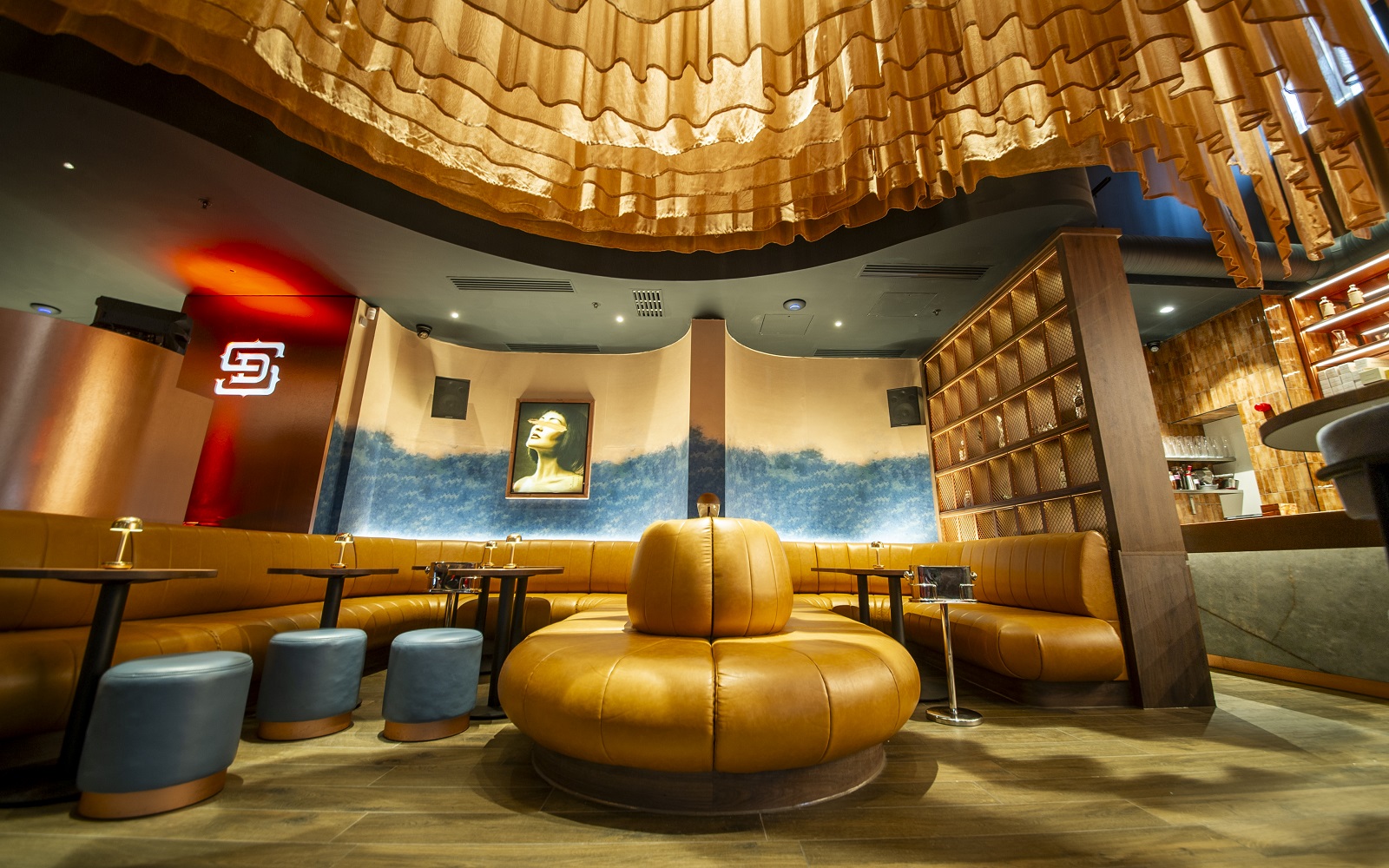 central round banquette style seating with bespoke Newmor mural on the wall in Dear Sailor