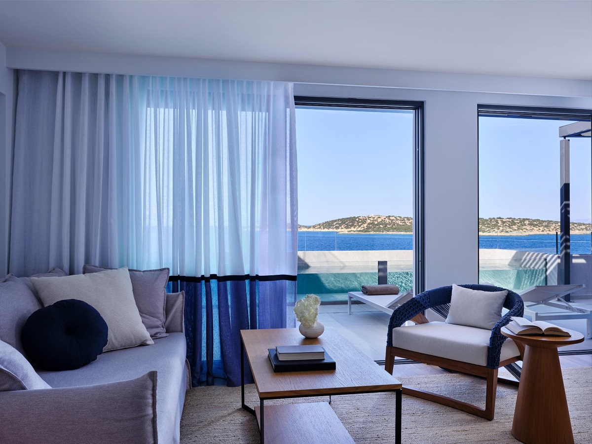 hotel guestroom in shades of white and blue refelcting the seaview and private swimming pool