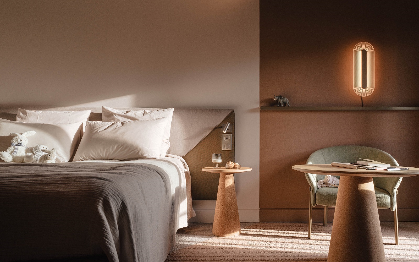 bed with wooden table and chair and wall light in novotel designs by Ligne roset