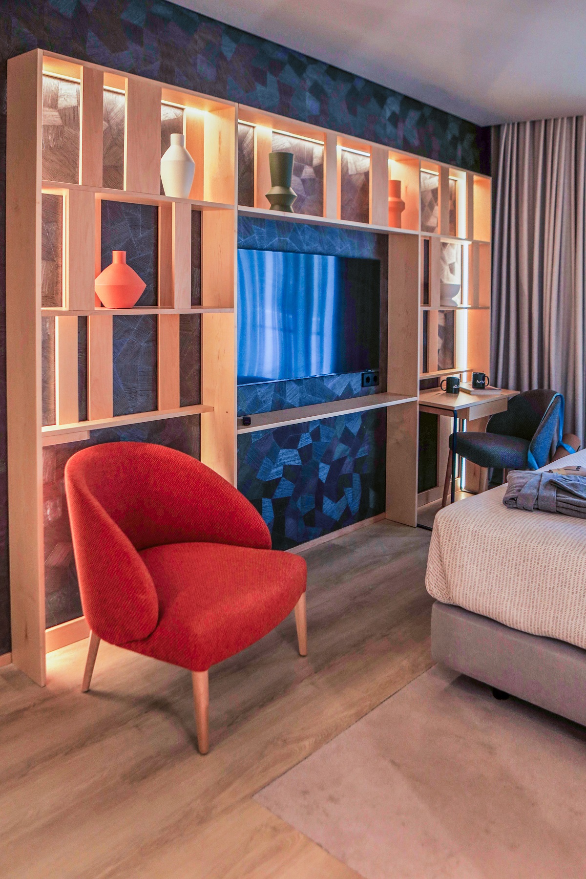 wall feature with shelves in hotel guestroom with red chair