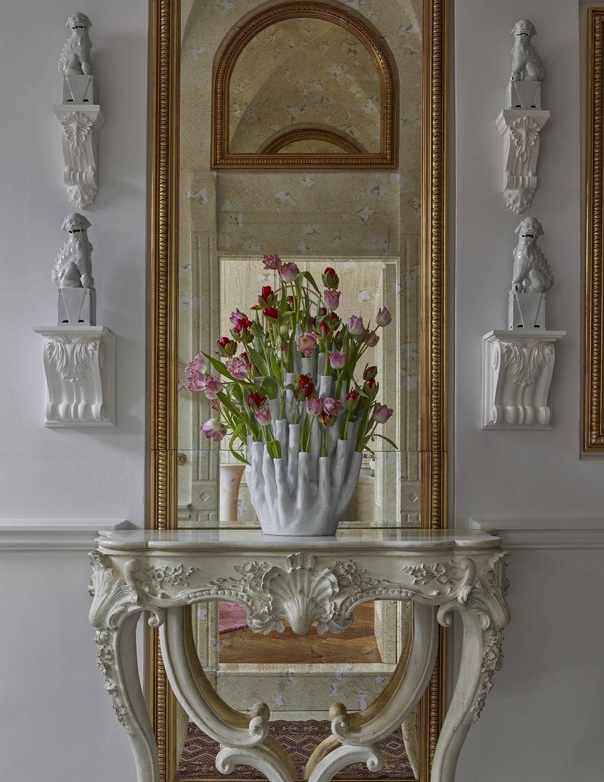 rococo hall stand with vase of tulips in front of mirror