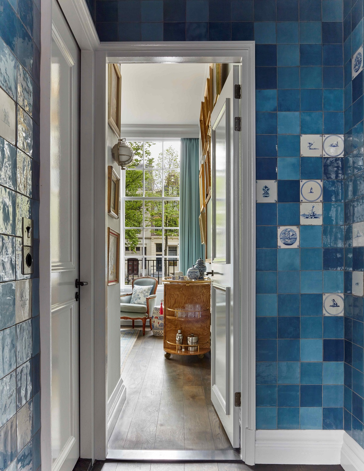 blue tiled wall with view into lounge and windows over the canal