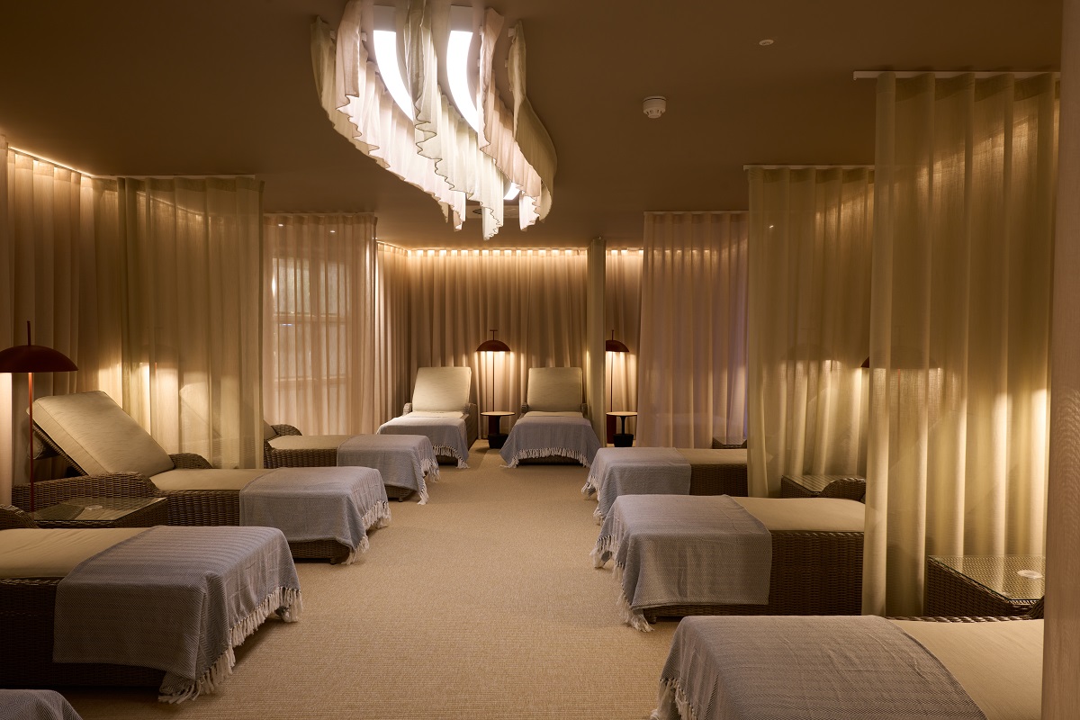 treatment room with illuminated sheer curtains and a wave chandelier