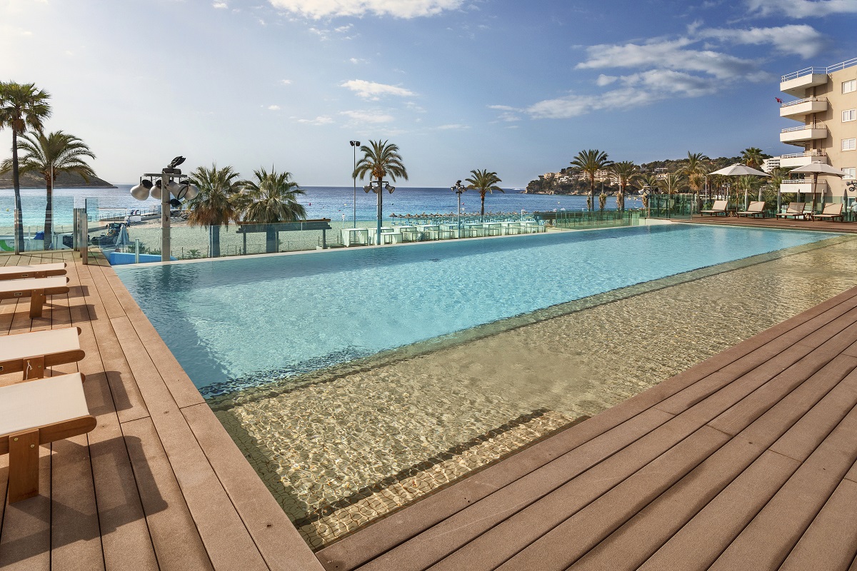 infinity pool with wooden decking and palm trees at Innside Wave Calvia Megaluf 