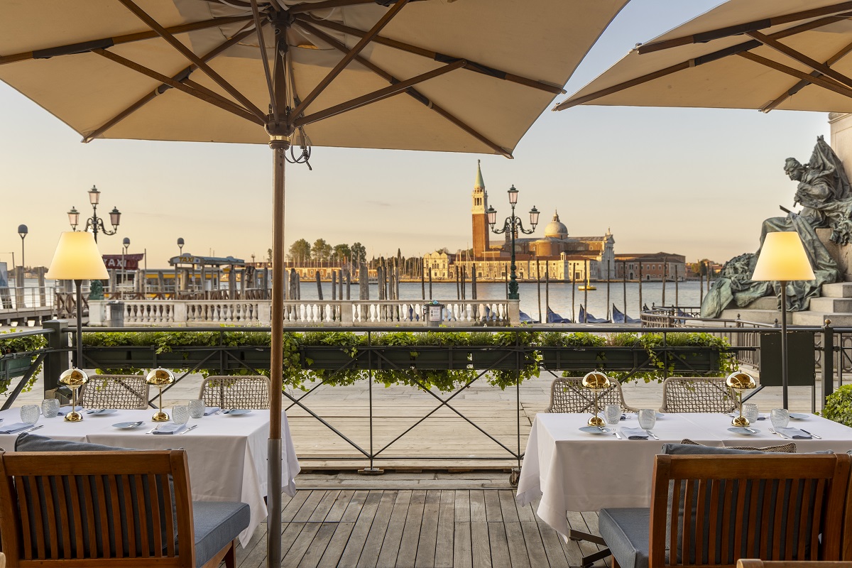 wooden deck with tables and parasols over the venetian canals