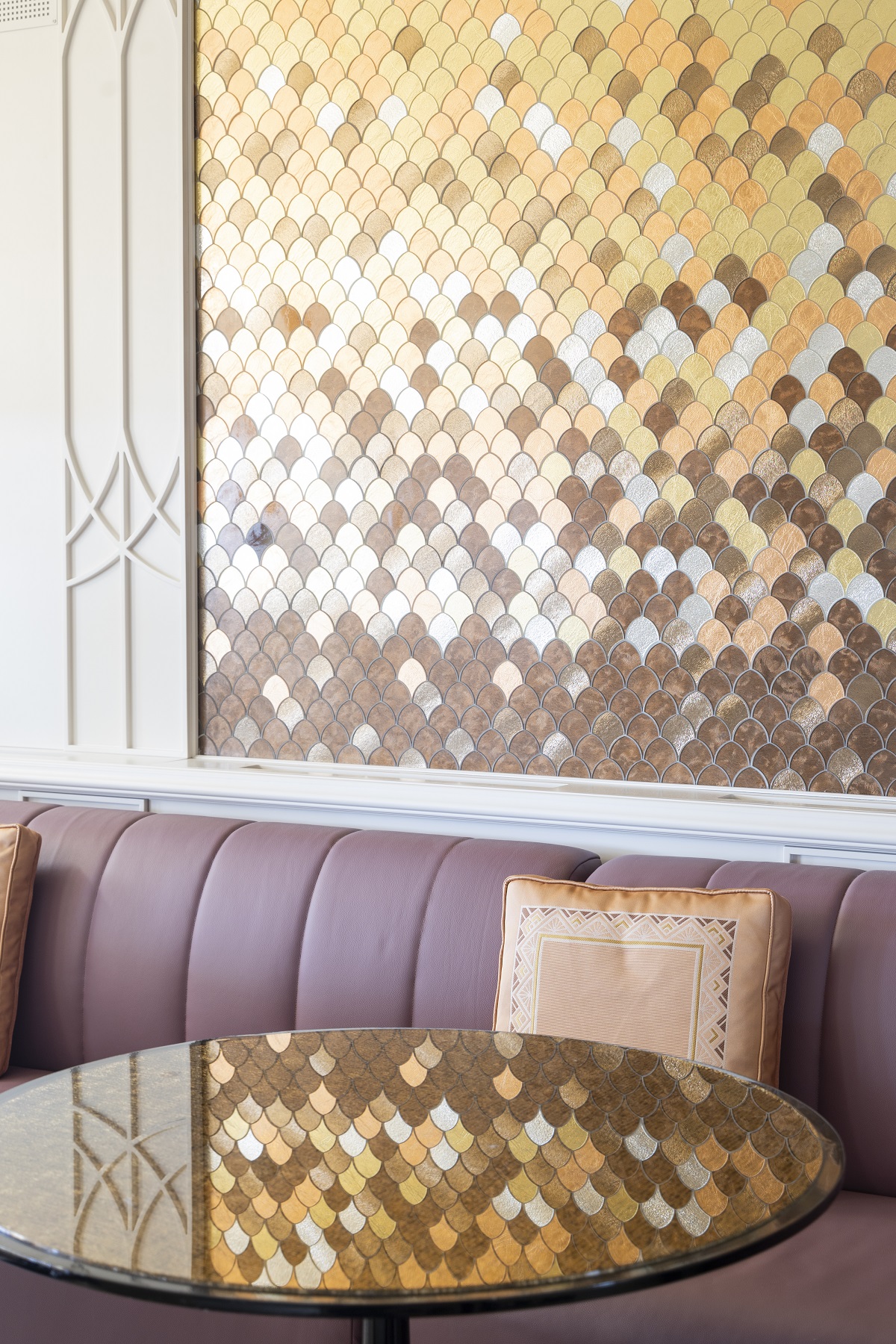 detail of patterned metal panel reflected in glass table top