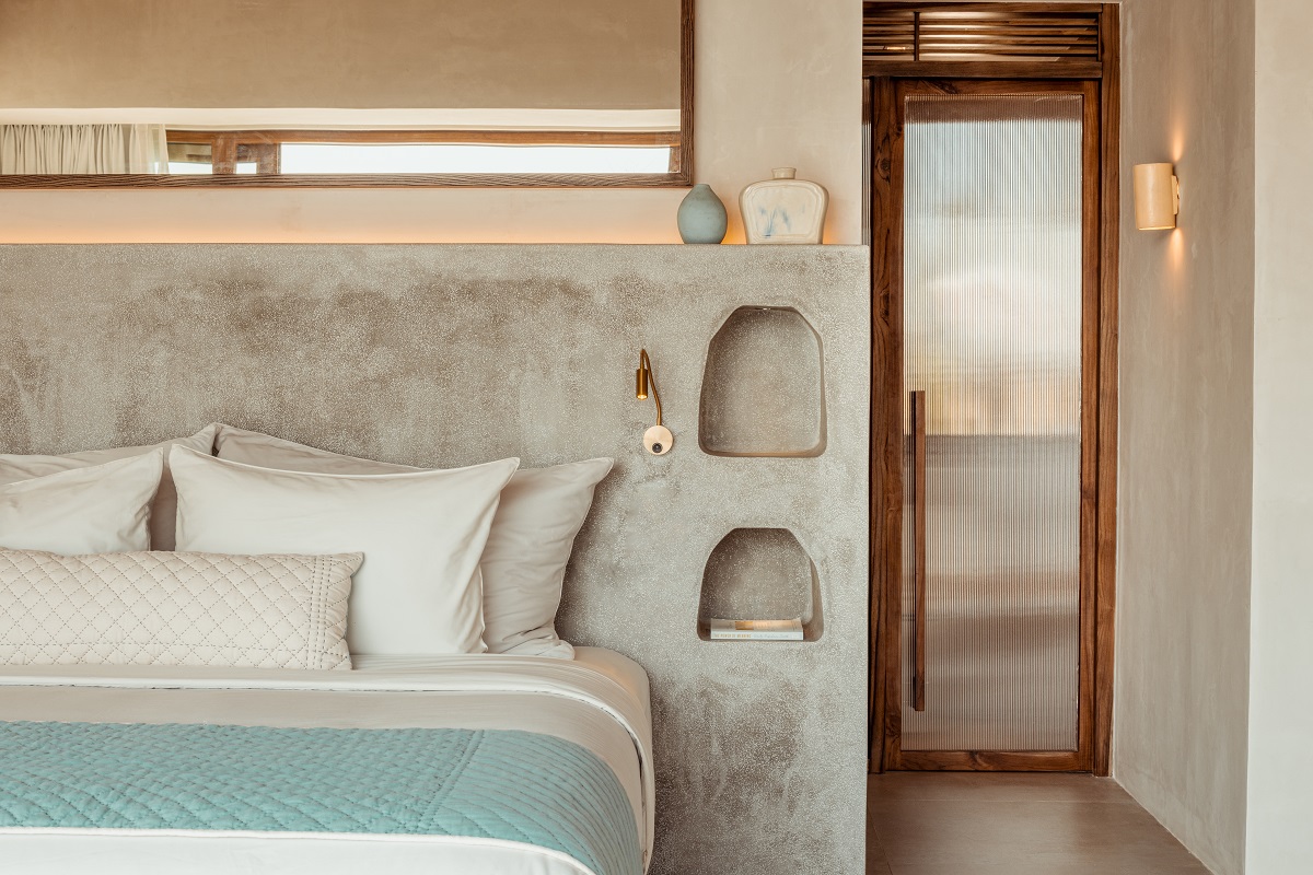 bedroom detail with natural stone and aqua colours on bed with wood and stone surfaces