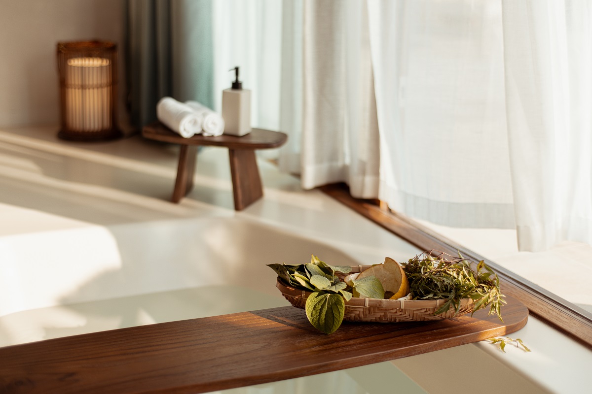 bath edge detail in suite with wooden shelf and herbs