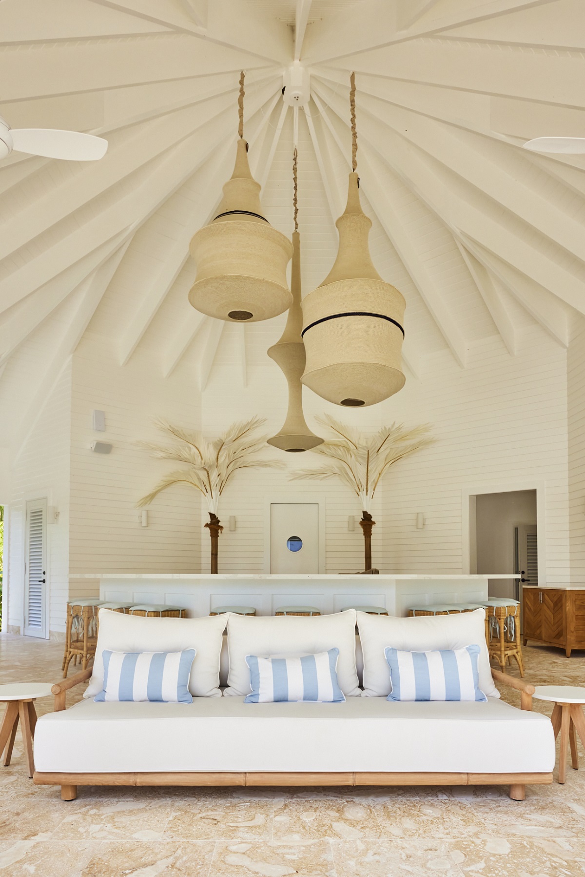 white couch and blue striped cushions in beach bar