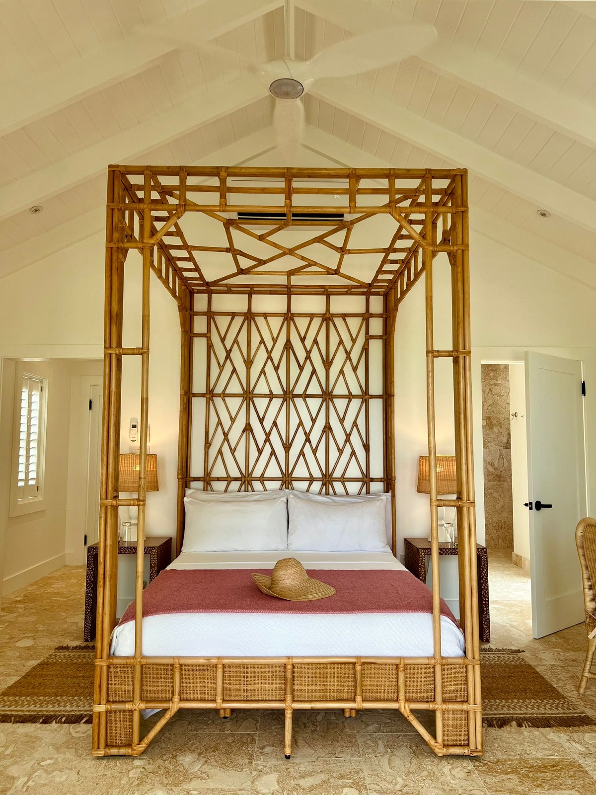 four poster canopied wicker bed under pitched roof