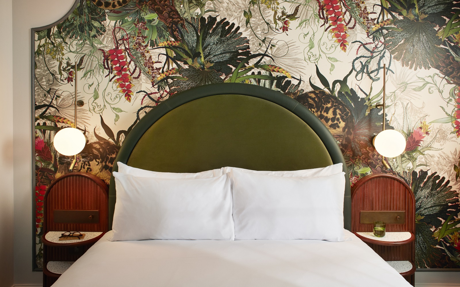 floral wallpaper behind moss green bedhead in Hype London guestroom