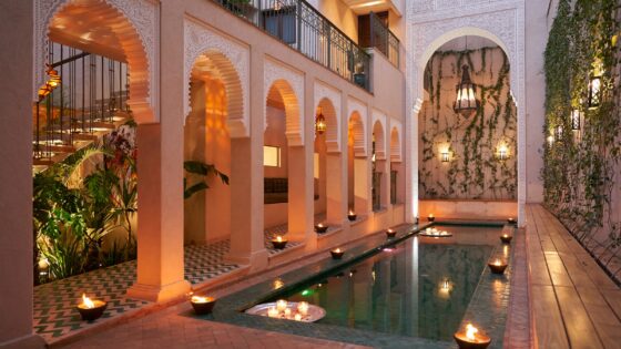 candlelight and arches around courtyard pool in IZZA Marrakech