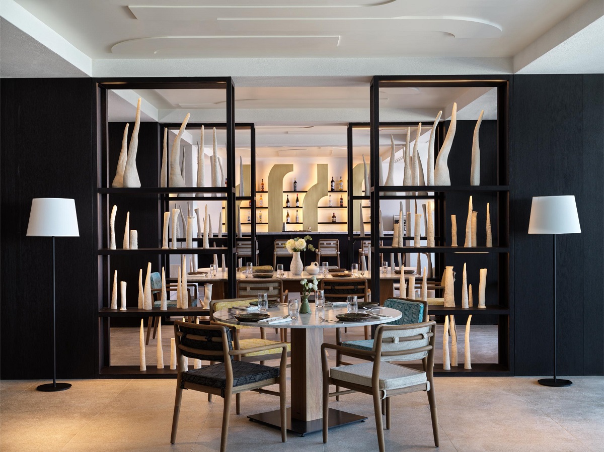 dining area in front of wood room partition with bar in the background in IHG Crete