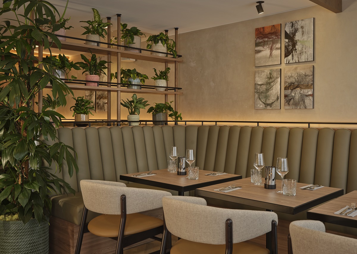 plants, light wood and olive green in restaurant design in The Reach