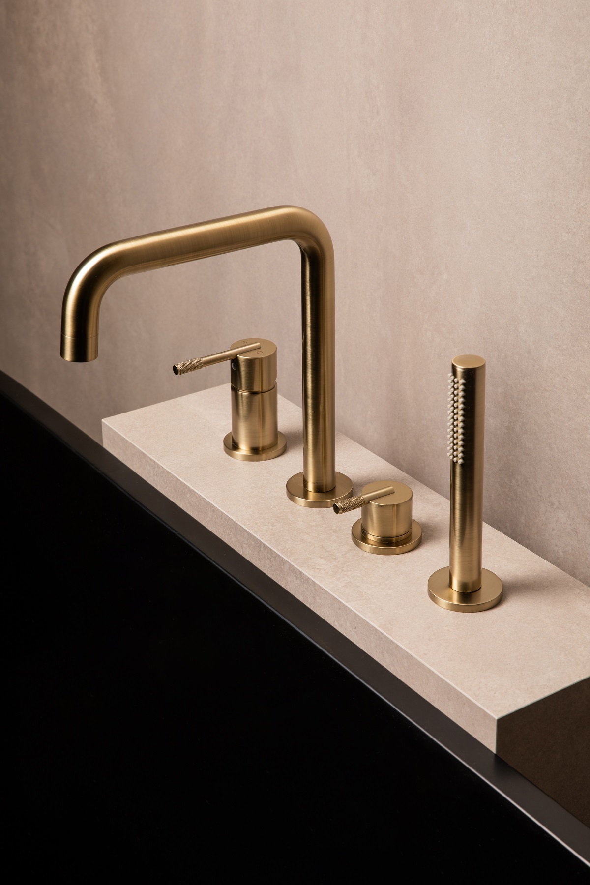 Minimalist design taps in gold on stone surface