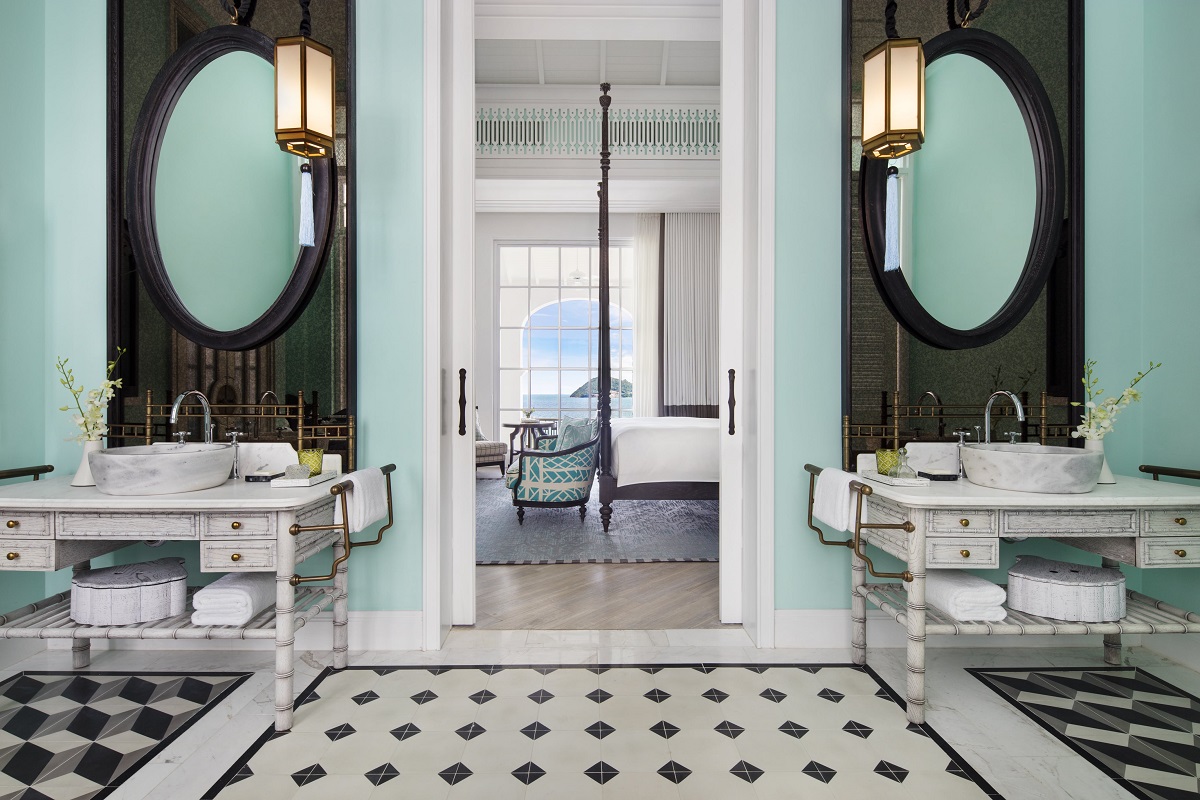 black and white floor and blue walls in bathroom with views through to the bedroom and the sea