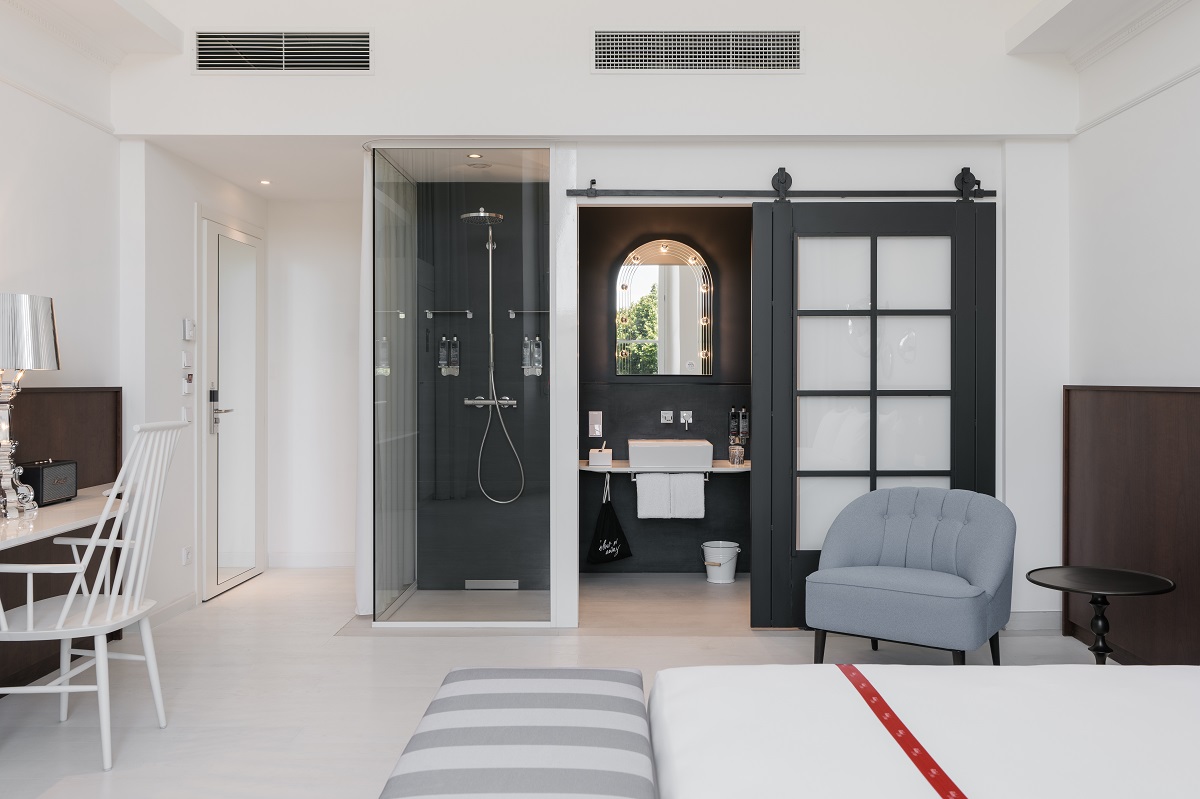 view from white interior of Ruby guestroom into ensuite with arched mirror