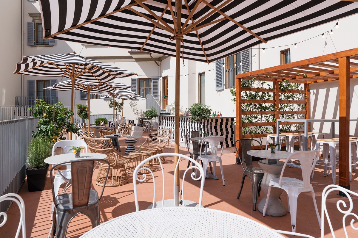 striped umbrellas above tables in courtyard at Ruby Bea