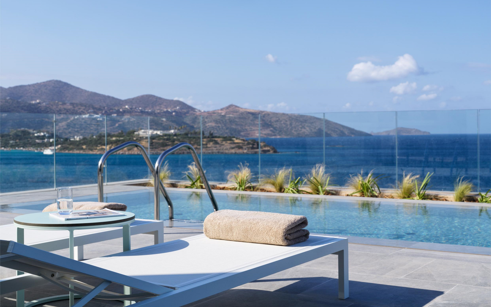 white sunloungers with private pool in front all overlooking Mirabella bay Crete