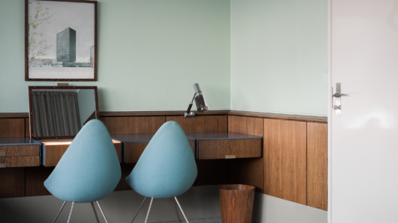 blue drop chairs by Arne Jacobsen in front of wooden desk in Radisson Collection Royal Hotel