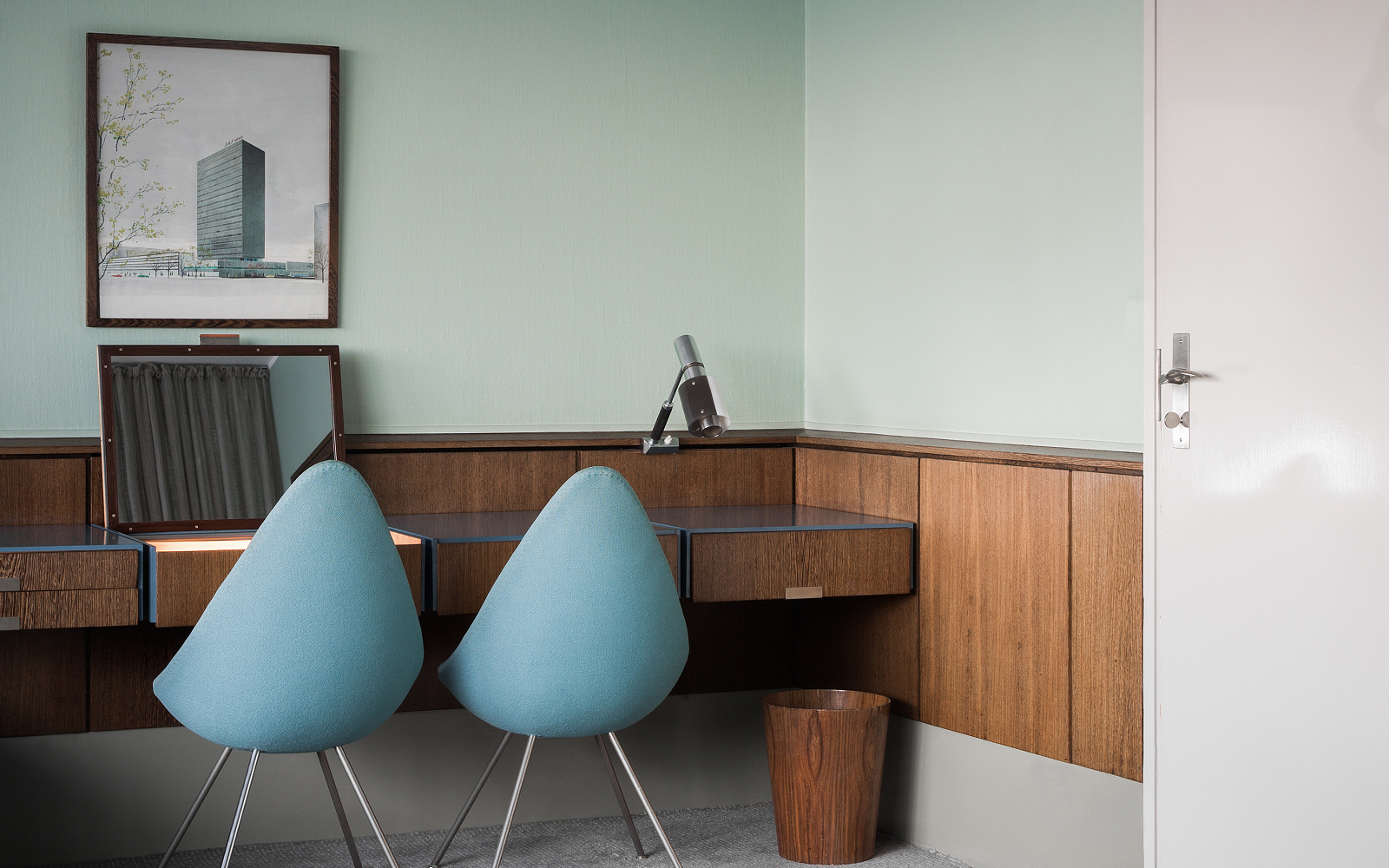 blue drop chairs by Arne Jacobsen in front of wooden desk in Radisson Collection Royal Hotel