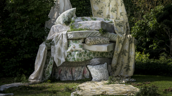 piles of cushions under a tree in sanderson fabric