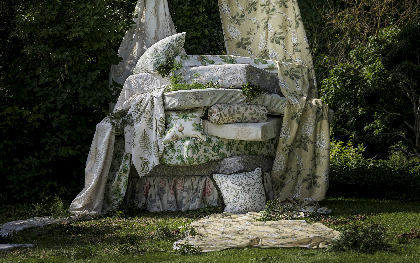 piles of cushions under a tree in sanderson fabric