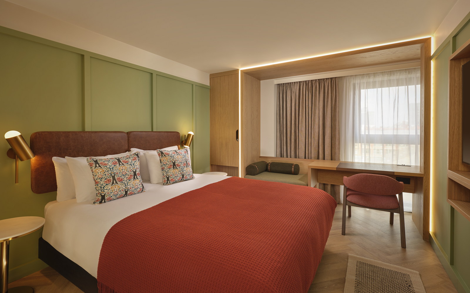 green wall and orange throw on bed in guestroom at The Reach Manchester