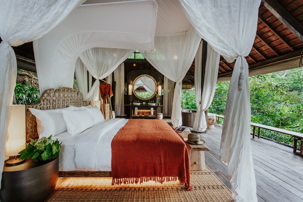 The master bedroom is lavish and looks out across typical tropical Bali scenery