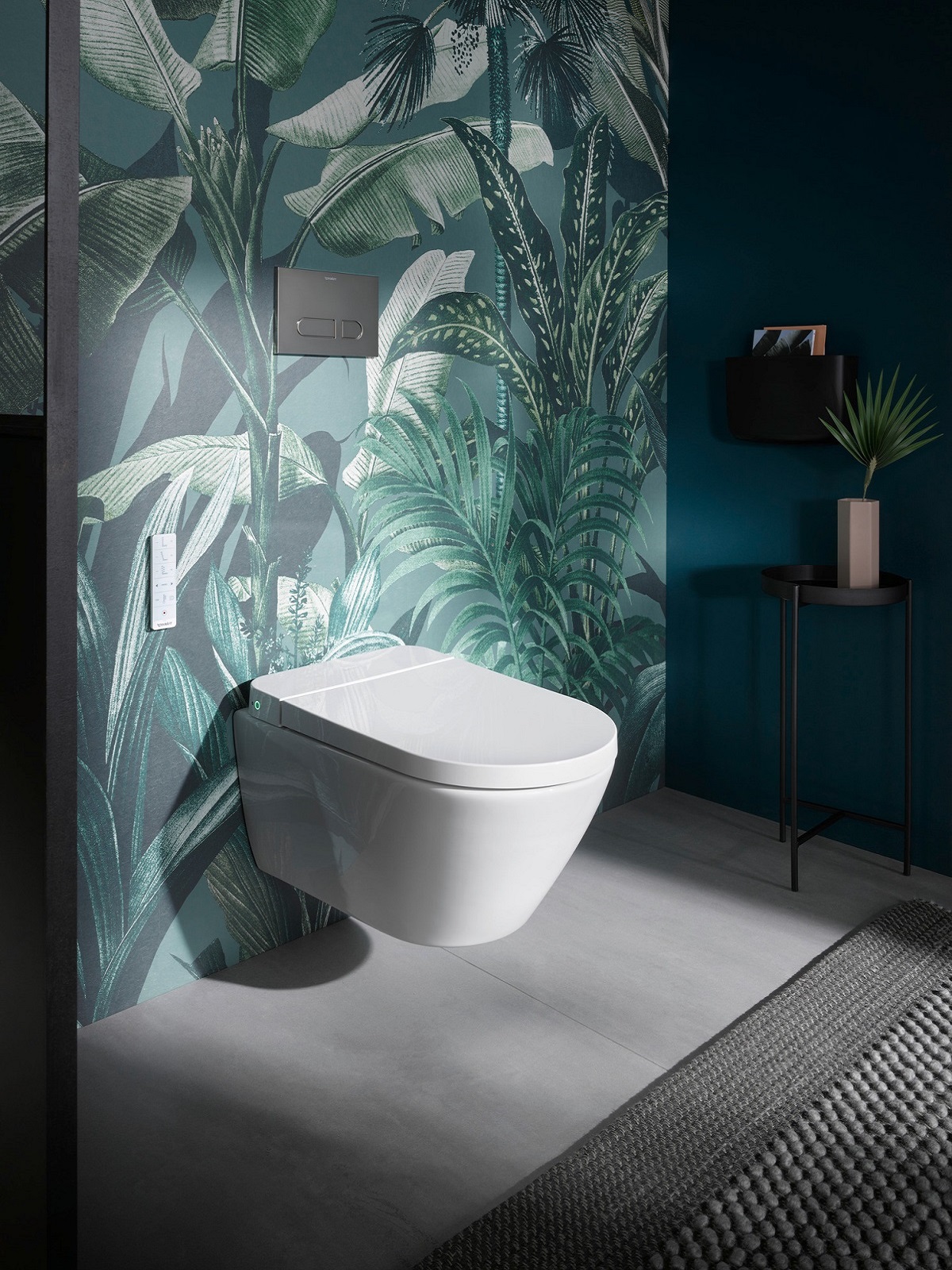 white wall hung toilet against palm tree patterned wallpaper