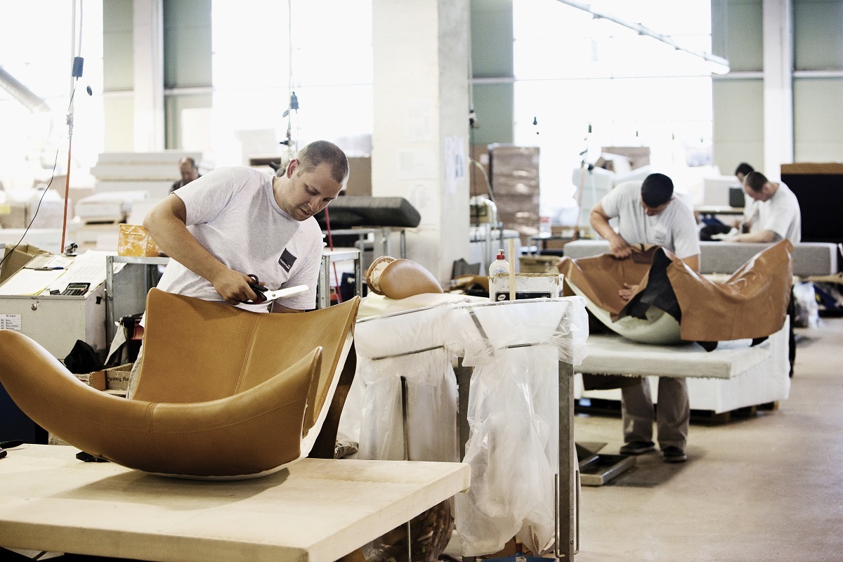 Upholsterers in BoConcept's factory stretch leather across the frame of a chair