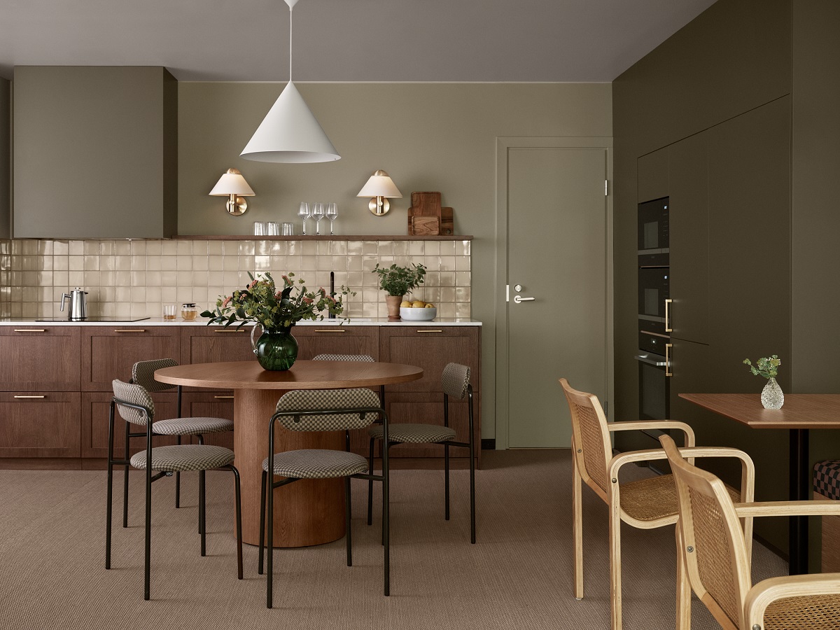 sage green walls, cream tiles and wooden surfaces in kitchen BobW Helsinki