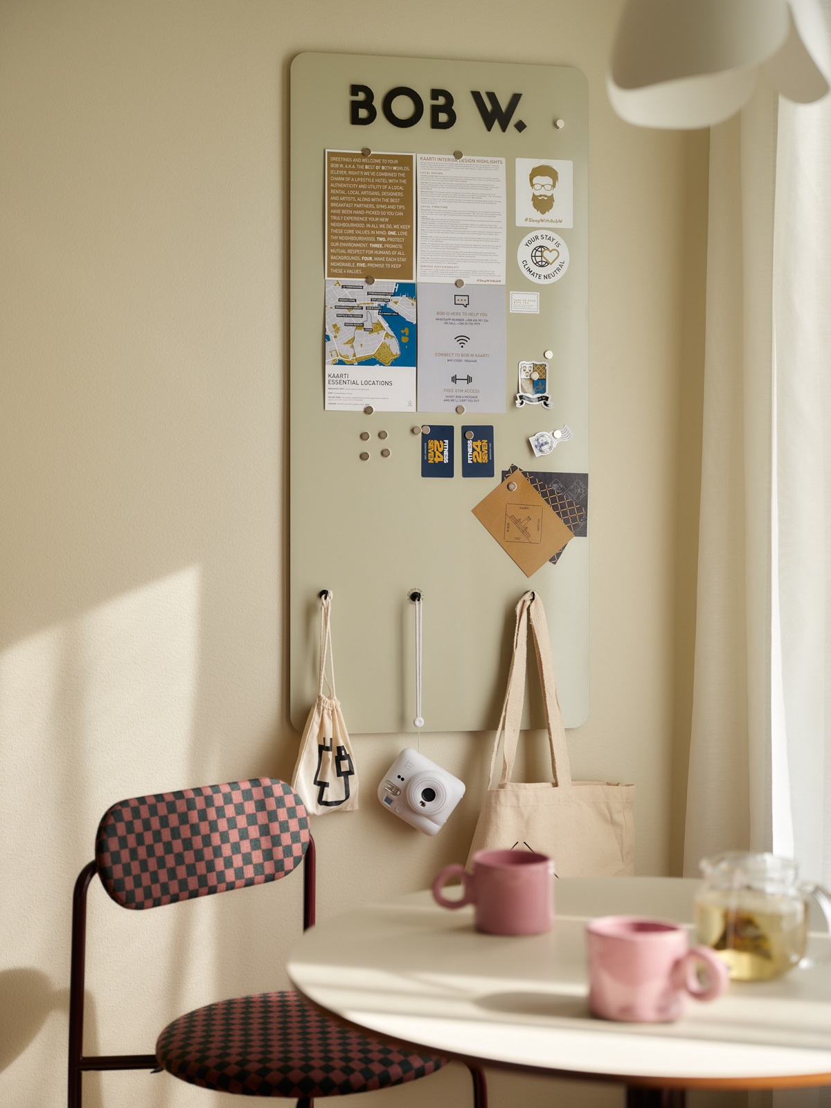 table detail with pink mug and pinboard in the background