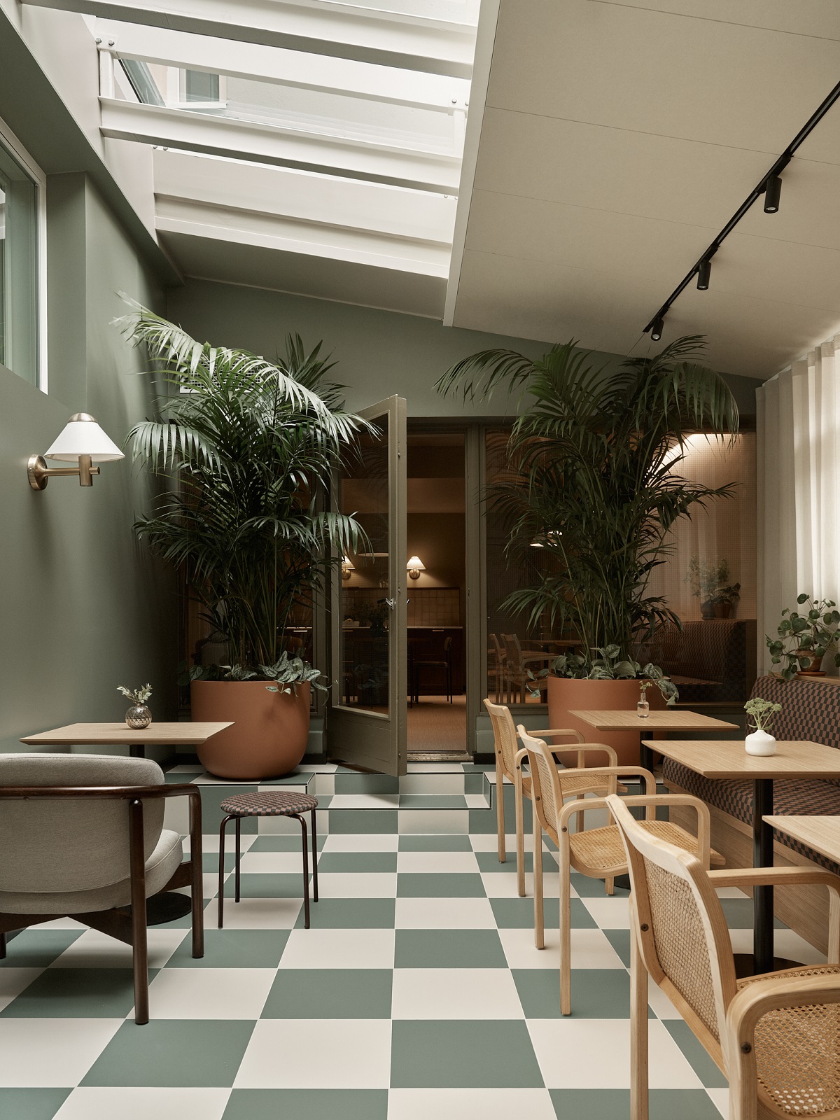 green and white checked floor, green walls, plants and wooden furniture in Bob W