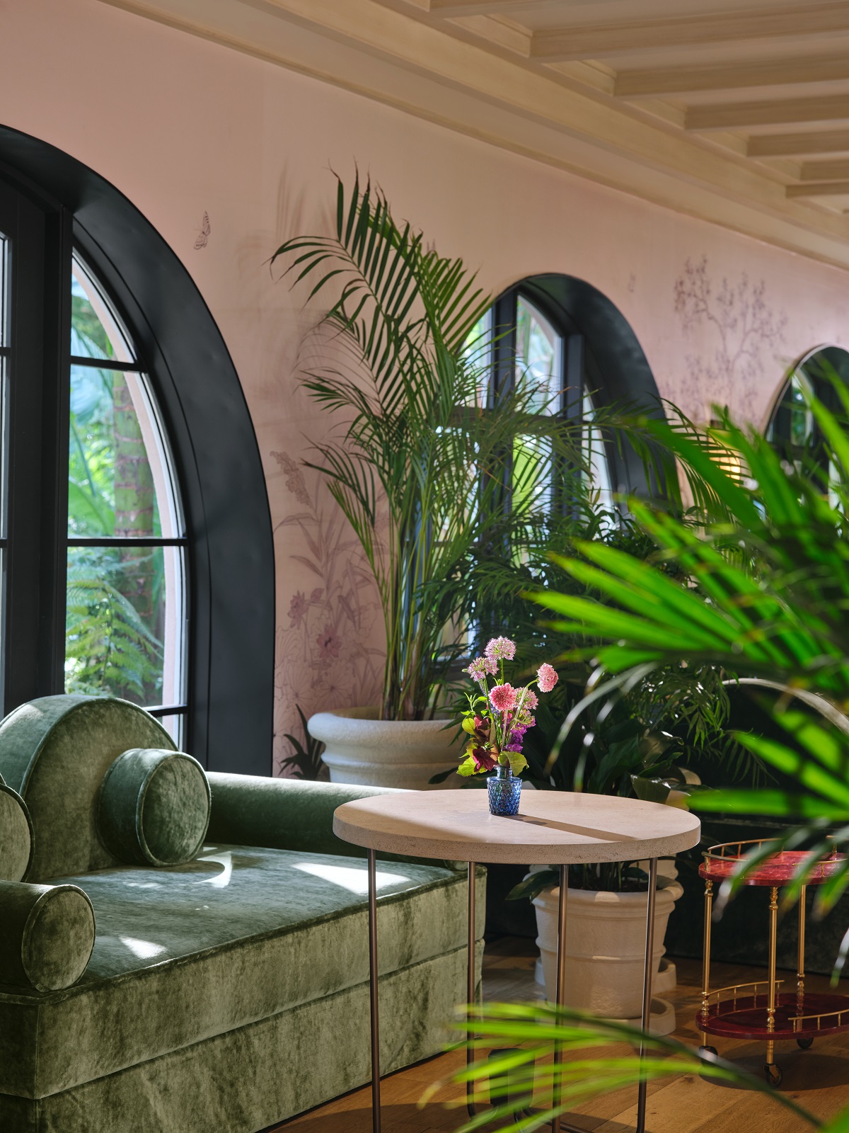 green couches, a painted mural and plants in the Living Room at hotel Bel Air